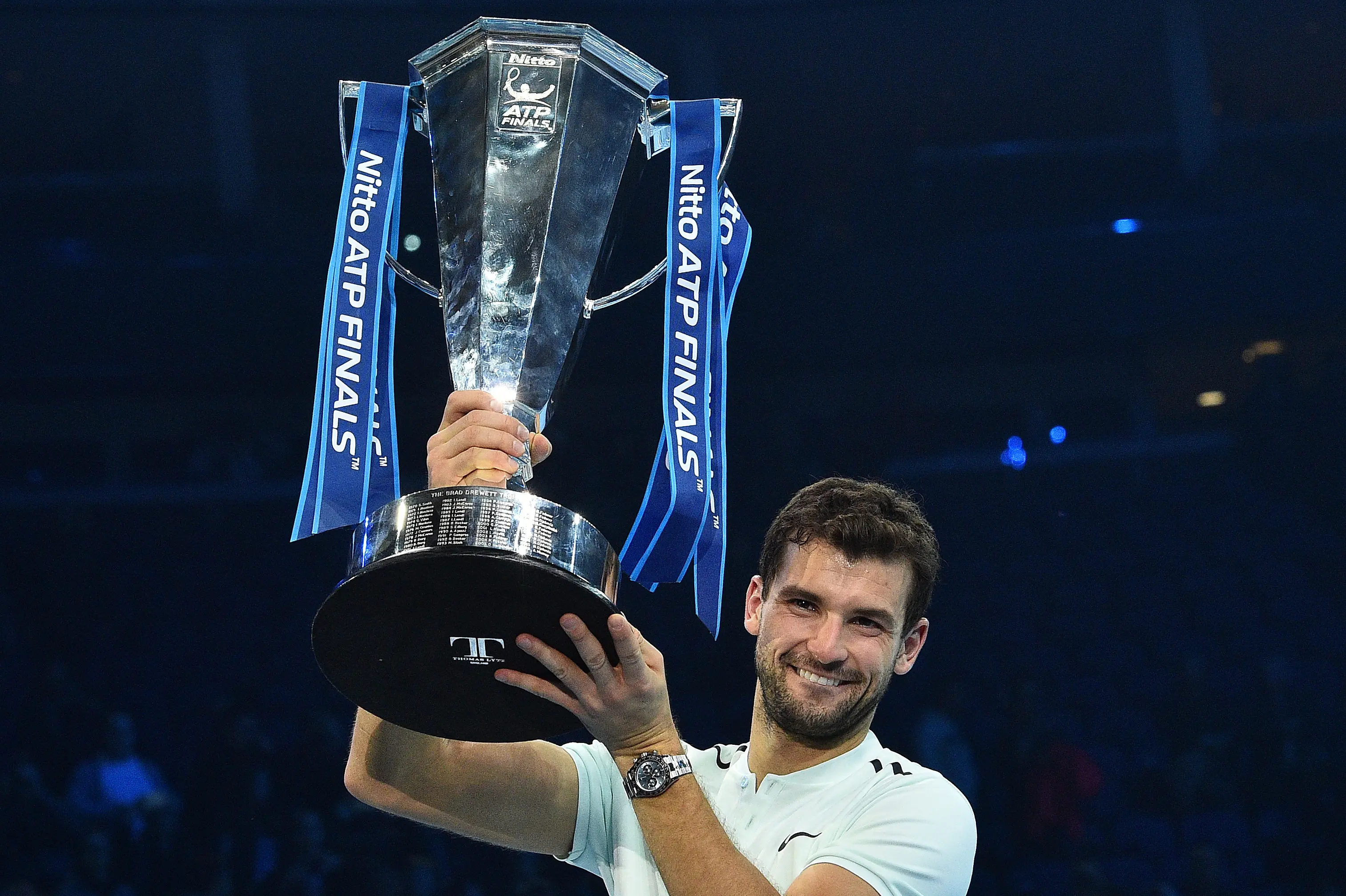 Grigor Dimitrov rayakan gelar ATP World Tour Finals usai mengalahkan David Goffin 7-5, 4-6, 6-3 di di O2 Arena, Senin (20/11/2017) dini hari WIB. (AFP/Glyn Kirk)