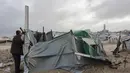 Ribuan tenda yang menjadi tempat tinggal keluarga pengungsi di Jalur Gaza rusak parah tersapu angin akibat badai musim dingin yang kuat. Tampak dalam foto, seorang pria Palestina yang mengungsi memperbaiki tenda yang didirikan di sepanjang pantai Kota Gaza saat angin musim dingin yang kencang menerpa wilayah tersebut pada Selasa 13 Januari 2026. (Omar AL-QATTAA/AFP)