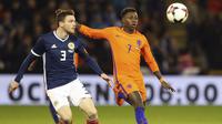 Pemain Skotlandia, Andrew Robertson (kiri) berebut bola dengan pemain Belanda, Quincy Promes pada laga persahabatan di Pittodrie, Aberdeen, Skotlandia (9/11/2017). Belanda menang 1-0. (Andrew Milligan/PA via AP)