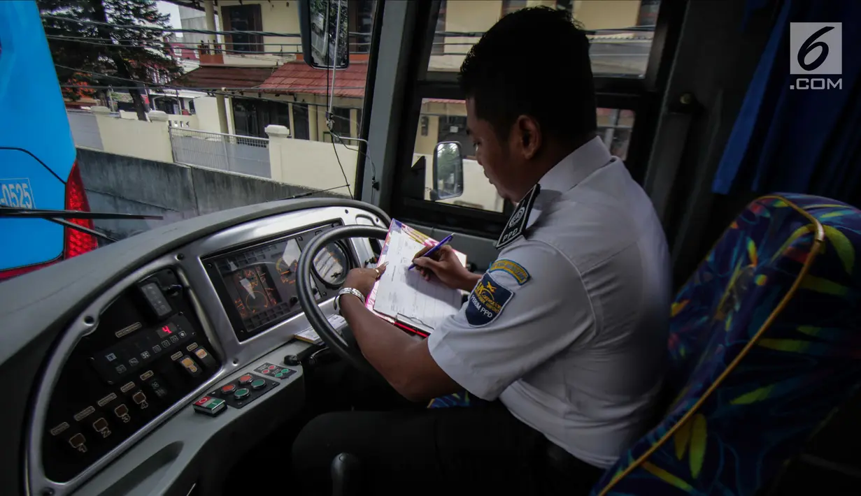 Petugas duduk dalam bus Transjabodetabek Premium saat menunggu calon penumpang di Tamini Square, Jakarta, Kamis (14/12). Kapasitas bus tersebut dapat menampung 41 penumpang dan dilengkapi fasilitas penunjangnya. (Liputan6.com/Faizal Fanani)