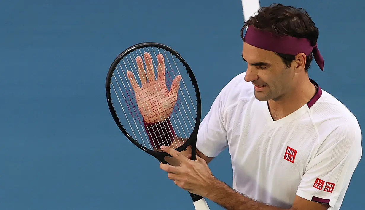 Petenis Swiss, Roger Federer, merayakan kemenangan atas petenis AS, Tennys Sandgren, pada perempat final Australia Open 2020 di Melbourne, Selasa (28/1). Federer menang 6-3, 2-6, 2-6, 7-6 (10-8), 6-3 atas Sandgren. (AFP/David Gray)