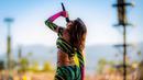 Anitta mengguncang panggung Coachella 2022 dengan outfit yang colorful. Crop top dengan desain off-shoulder lengan panjang, serasi dengan legging panjang bermotif loreng macan berwarna-warni. Foto: Instagram.