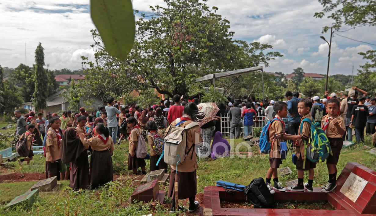 Anak-anak sekolah dasar ikut mengantar jenazah almarhum, Ahmad Kurniawan menuju Tempat Pemakaman Umum, Kalisari di Cijantung, (11/1/2016). (Bola.com/Nicklas Hanoatubun)