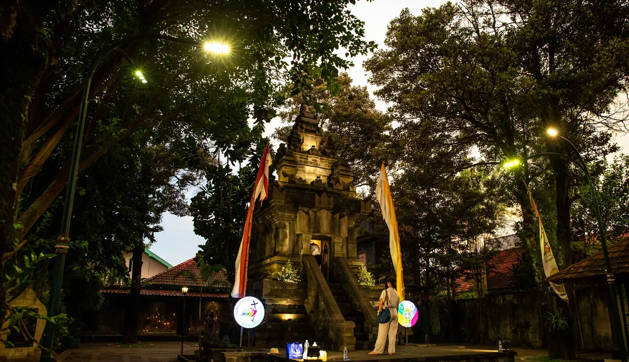 Pendekatan ini dikenal sebagai upaya inkulturasi, yakni memadukan nilai-nilai iman Katolik dengan tradisi setempat tanpa menghilangkan makna utama peribadatan. Tampak dalam foto, para umat Katolik berdoa di Kuil Hati Kudus Yesus pada malam Natal di Ganjuran, Bantul, Yogyakarta, pada Rabu 24 Desember 2025. (DEVI RAHMAN/AFP)
