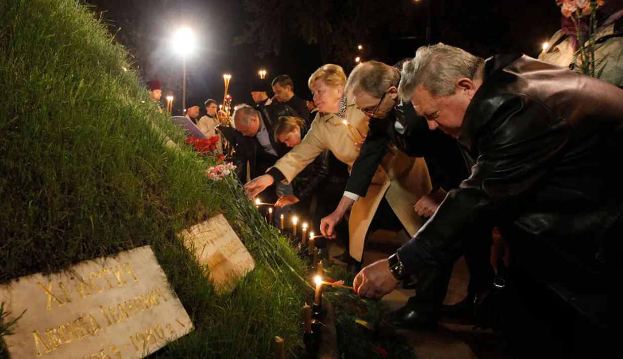 Sejumlah orang menyalakan lilin sebelum dimulai upacara peringatan 28 tahun bencana nuklir Chernobyl, di Kiev, Ukraina (26/4/2014). (REUTERS/Valentyn Ogirenko)