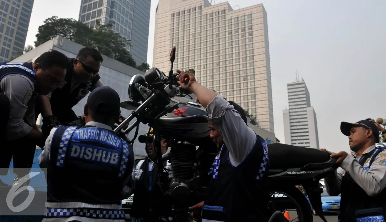 Petugas Dishub, mengangkut sepeda motor saat razia gabungan di kawasan Tanah Abang, Jakarta, Jumat (12/6/2015). Razia gabungan Dishub, Garnisun dan Satlantas bertujuan untuk mengantisipasi arus lalu lintas yang kerap macet. (Liputan6.com/Johan Tallo)