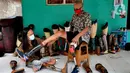 Ronald Regen (33), perajin yang juga penyandang disabilitas memasangkan kaki palsu ke pelanggan di Dusun IV Rawailat, Desa Dayeuh, Cileungsi, Bogor, Jawa Barat, Selasa (29/3/2022). UMKM kaki palsu yang sempat bangkrut akibat pandemi COVID-19 mulai bangkit sejak awal tahun. (merdeka.com/Arie Basuki)