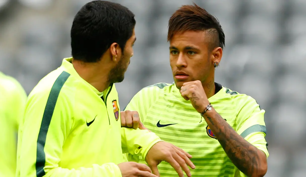 Penyerang Barcelona, Neymar berbincang dengan Luis Suarez saat menjalani sesi latihan di Allianz Arena, Munich, Jerman (11/5/2015).  Barcelona akan menantang Bayern Muenchen di leg kedua semifinal Liga Champions. (Reuters/Michaela Rehle)