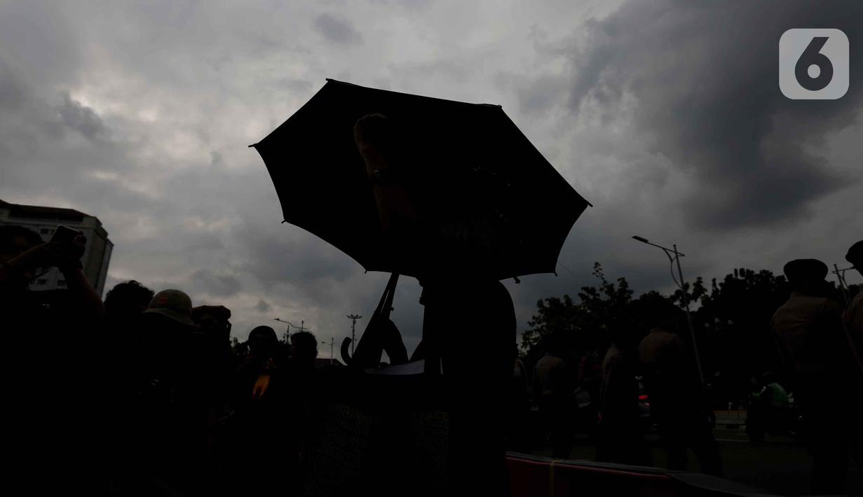 Siluet dari Sumarsih, ibu dari Bernardinus Realino Norma Irawan, korban Tragedi Semanggi I (1998), saat mengikuti peringatan 19 tahun Aksi Kamisan di Jalan Medan Merdeka Utara atau di seberang Istana Merdeka, Jakarta, 15 Januari 2026. (Liputan6.com/Helmi Fithriansyah)