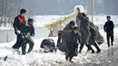 Pemuda Kashmir bermain dengan salju di tepi Danau Dal setelah salju turun di Srinagar, India bagian utara, Sabtu (5/1). Wilayah Kashmir mengalami salju selama beberapa hari yang mengakibatkan terputus jalan raya Jammu-Srinagar. (TAUSEEF MUSTAFA/AFP)