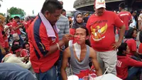 Pelukis wajah menggunakan duel Malaysia dan Timnas Indonesia U-22 di SEA Games sebagai ajang cari keuntungan. (Liputan6.com/Cakrayuri Nuralam)