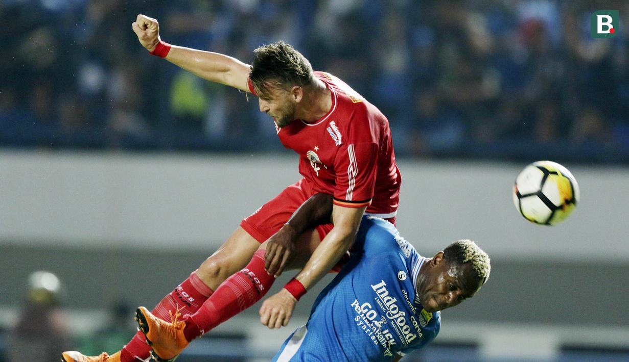 Bek Persib Bandung, Victor Igbonefo, duel udara dengan striker Persija Jakarta, Marko Simic, pada laga Liga 1 di Stadion GBLA, Jawa Barat, Minggu (23/9/2018). Persib menang 3-2 atas Persija. (Bola.com/M Iqbal Ichsan)
