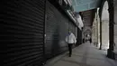 Seorang pria berjalan melewati toko-toko yang tutup di Algiers, Aljazair, Rabu (29/4/2020). Aljazair melonggarkan langkah-langkah karantina akibat virus corona COVID-19 sejak hari pertama bulan suci Ramadan dengan memperpendek jam malam dan memungkinkan beberapa kegiatan komersial. (AP Photo/Toufik