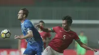 Duel pemain timnas Indonesia U-23, Bagas Adi Nugroho (kanan) dengan pemain Uzbekistan pada laga PSSI Anniversary Cup 2018 di Stadion Pakansari, Bogor, (03/5/2018). Indonesia U-23 bermain imbang 0-0. (Bola.com/Nick Hanoatubun)