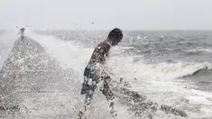 Seorang anak laki-laki mencari botol-botol plastik untuk didaur ulang ditengah deburan gelombang akibat Topan Koppu di Teluk Manila, Minggu (18/10). Topan Koppu melanda Filipina timur laut dan merusak rumah-rumah. (REUTERS/Romeo Ranoco)