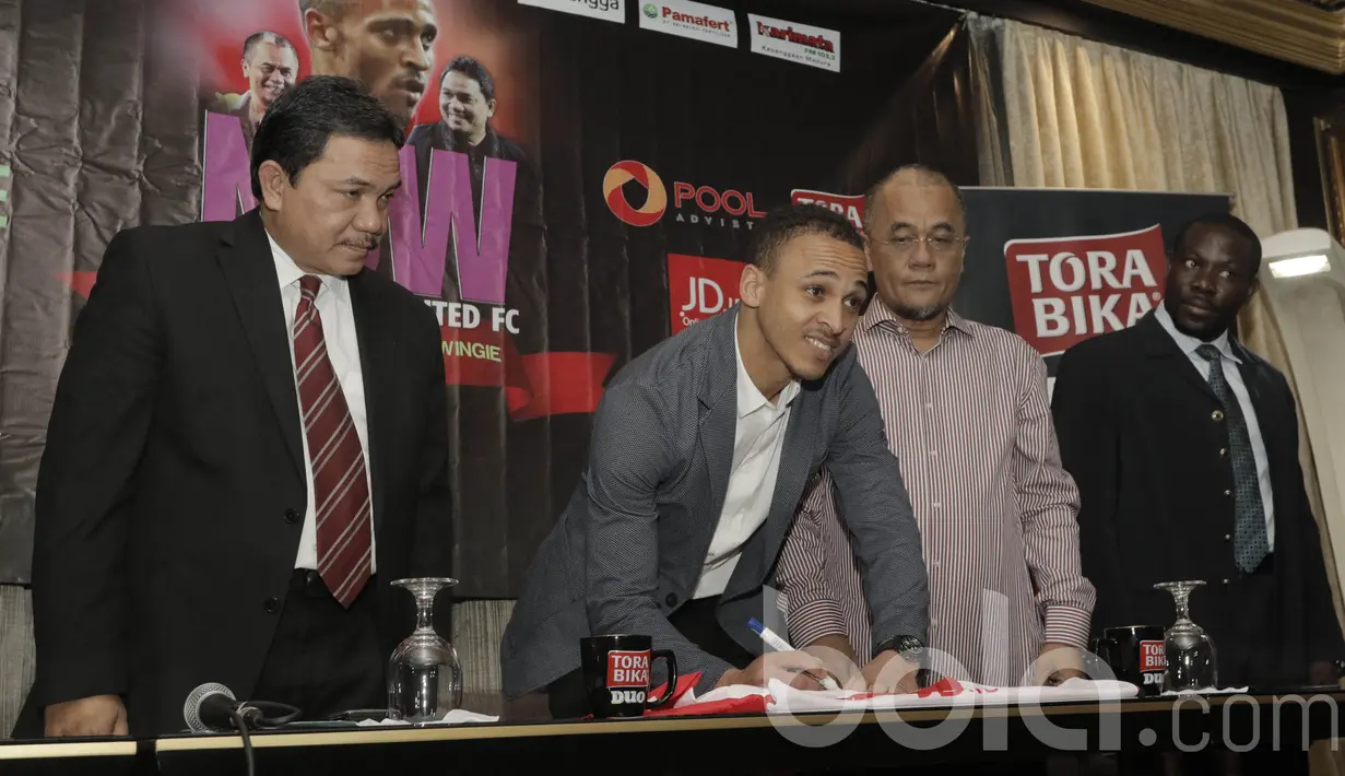 Marquee player Madura United, Peter Odemwingie, menandatangani kostum Madura United. Ia mendapat nomor punggung 24 untuk berkiprah di Liga 1 Indonesia. (Bola.com/M Iqbal Ichsan)