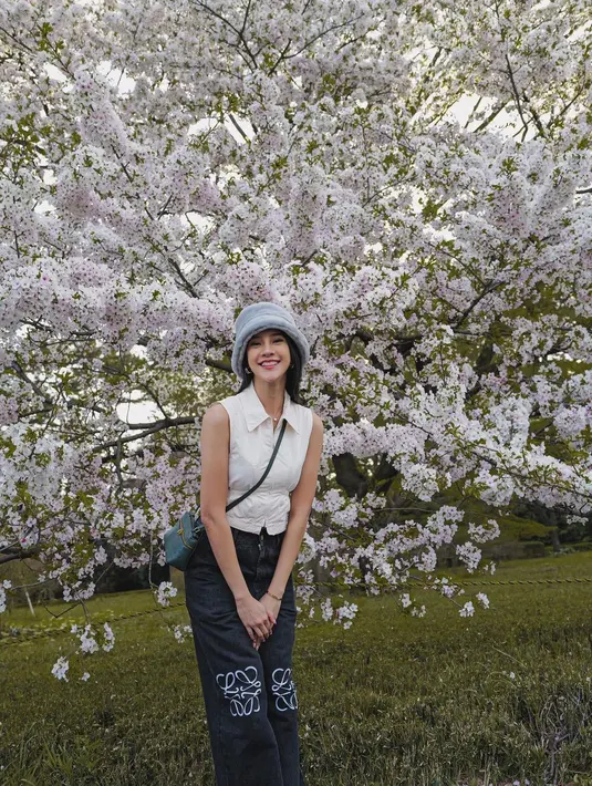 Anya Geraldine mengunggah potret dirinya dengan latar pohon sakura berwarna putih yang sedang bermekaran. [Foto: Instagram/anyageraldine]