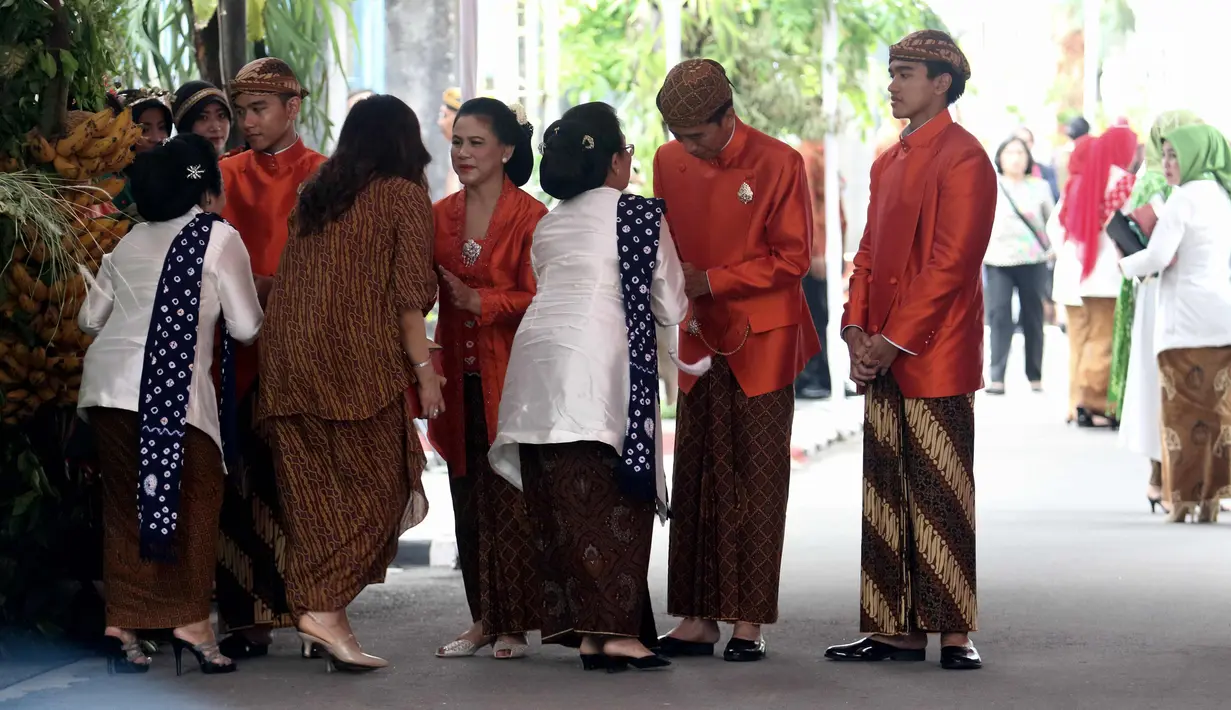 Presiden Joko Widodo (Jokowi) didampingi Ibu Negara, Iriana serta Gibran Rakabuming dan Kaesang Pangarep menyalami tamu yang pulang dari kediamannya di Jalan Kutai Utara, Solo usai prosesi siraman Kahiyang Ayu, Selasa (7/11). (Liputan6.com/Angga Yuniar)