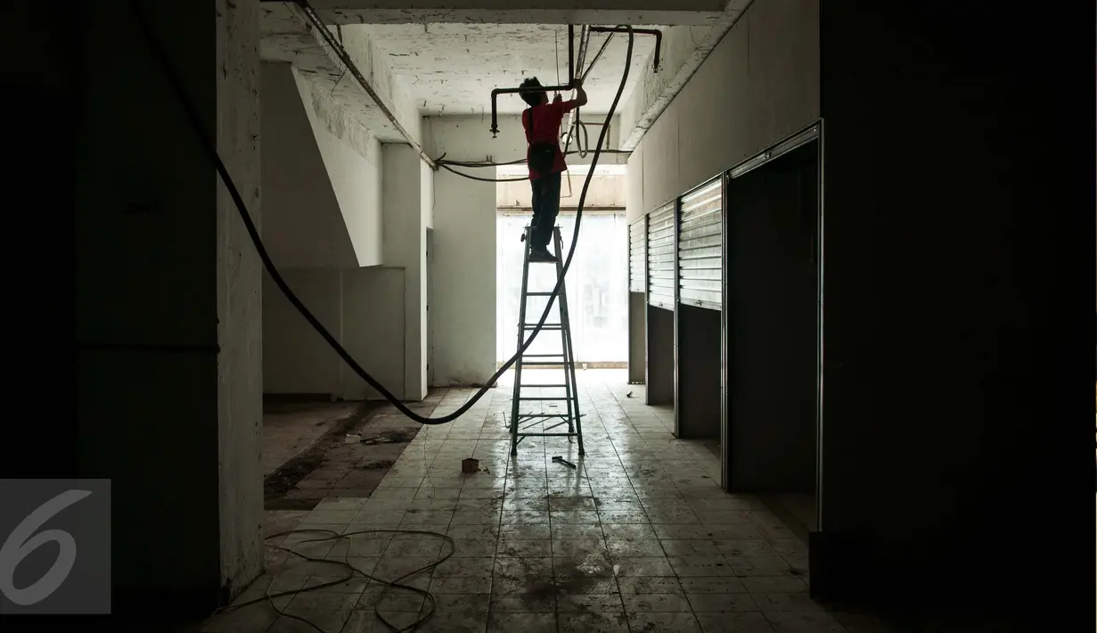 Pekerja memasang instalasi listrik untuk kios penampungan sementara bagi pedagang korban kebakaran di lantai 1 Blok V Pasar Senen, Jakarta, Jumat (24/2). Penampungan sementara tersebut dijadwalkan rampung pada Maret 2017. (Liputan6.com/Gempur M Surya)
