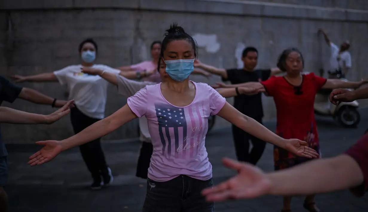 Sejumlah warga menari di sebelah Sungai Yangtze, Wuhan, Provinsi Hubei, China, 4 Agustus 2020. Wuhan kembali pulih sejak karantina terkait COVID-19 dicabut. (Hector Retamal/AFP)
