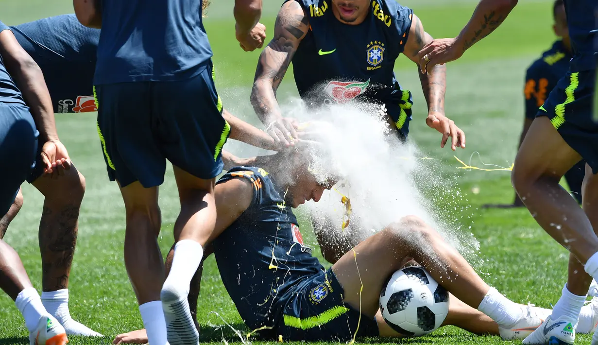Ekspresi pemain sepak bola Brasil, Coutinho saat diceploki telur dan tepung oleh rekan-rekannya dalam sesi latihan jelang Piala Dunia 2018 di Sochi, Rusia, Selasa (12/6). (Nelson Almeida/AFP)