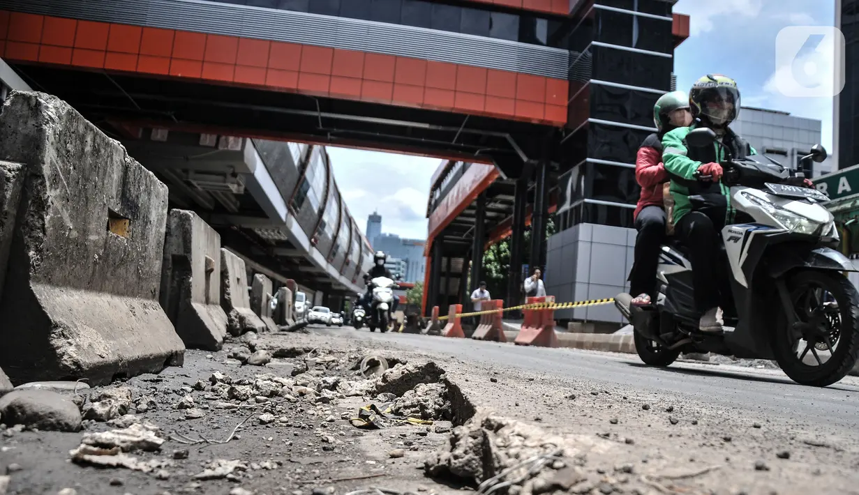 Pengendara motor menghindari jalan rusak dan berlubang saat melintas di Jalan HR Rasuna Said, Kuningan, Jakarta Selatan, Senin (24/10/2022). Kondisi jalan menjadi lebih parah saat turun hujan sehingga menyebabkan genangan yang menutupi lubang. (merdeka.com/Iqbal S. Nugroho)