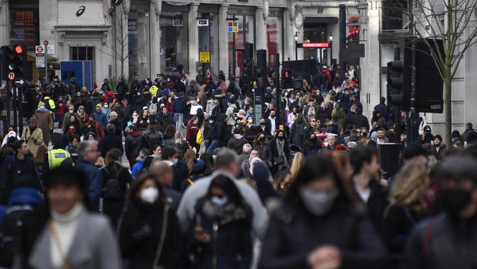 Orang-orang berjalan dengan mengenakan masker dan membawa tas belanjaan di Regent Street, setelah pelonggaran pembatasan virus corona COVID-19 menyusul berakhirnya kebijakan penguncian nasional atau lockdown kedua di Inggris, di London, Sabtu (5/12/2020). (AP Photo/Alberto Pezzali)