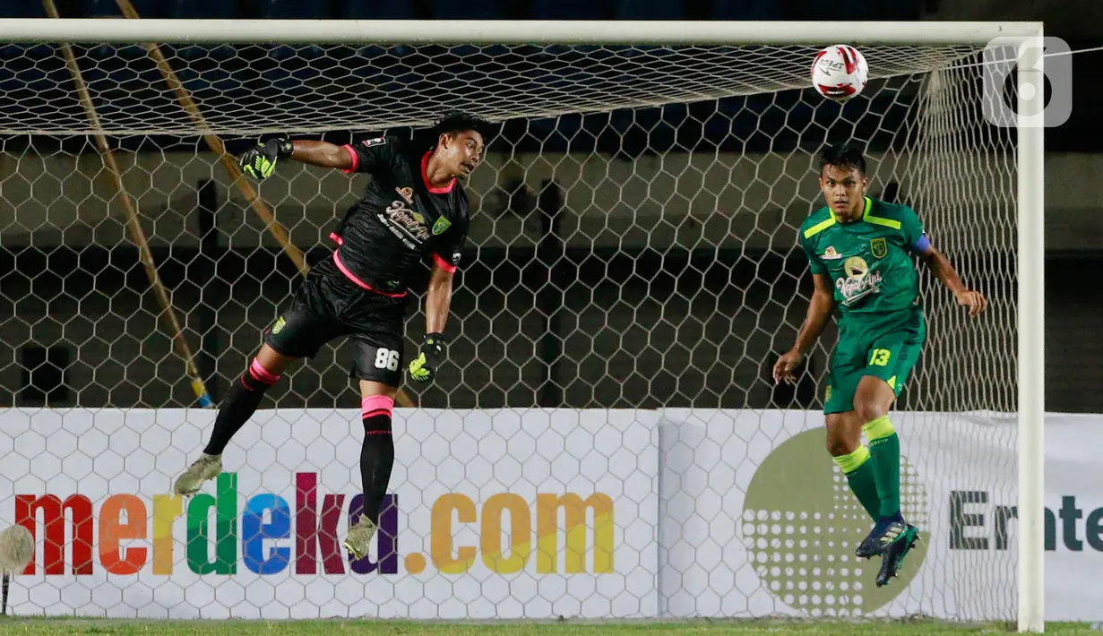 Kiper Persebaya Surabaya, Satria Tama (kiri) dan Rachmat Irianto (kanan) berusaha menghalau bola saat melawan Persik Kediri pada laga Piala Menpora 2021 di Stadion Si Jala Harupat, Bandung, Selasa (23/3/2021). (Bola.com/M Iqbal Ichsan)