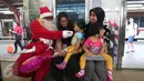 Sinterklas bercengkrama dengan para penumpang KRL di Jakarta, Jumat (25/12/2015). Keberadaan Sinterklas ini merupakan bentuk pelayanan KCJ dalam memperingati hari Natal. (Liputan6.com/Angga Yuniar)