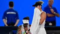 Belinda Bencic (berdiri) melewati Venus Williams pada babak pertama Australia Terbuka di Rod Laver Arena, Melbourne Park, Senin (15/1/2018). Bencic menang 6-3, 7-5. (AFP/Greg Wood)