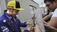 Pebalap Yamaha Movistar, Valentino Rossi, menyapa penggemarnya saat mendatangi paddock di Sirkuit Motegi, Tochigi Prefecture, Kamis (12/10/2017). MotoGP Jepang akan bergulir pada Minggu ini. (AP/Shizuo Kambayashi)
