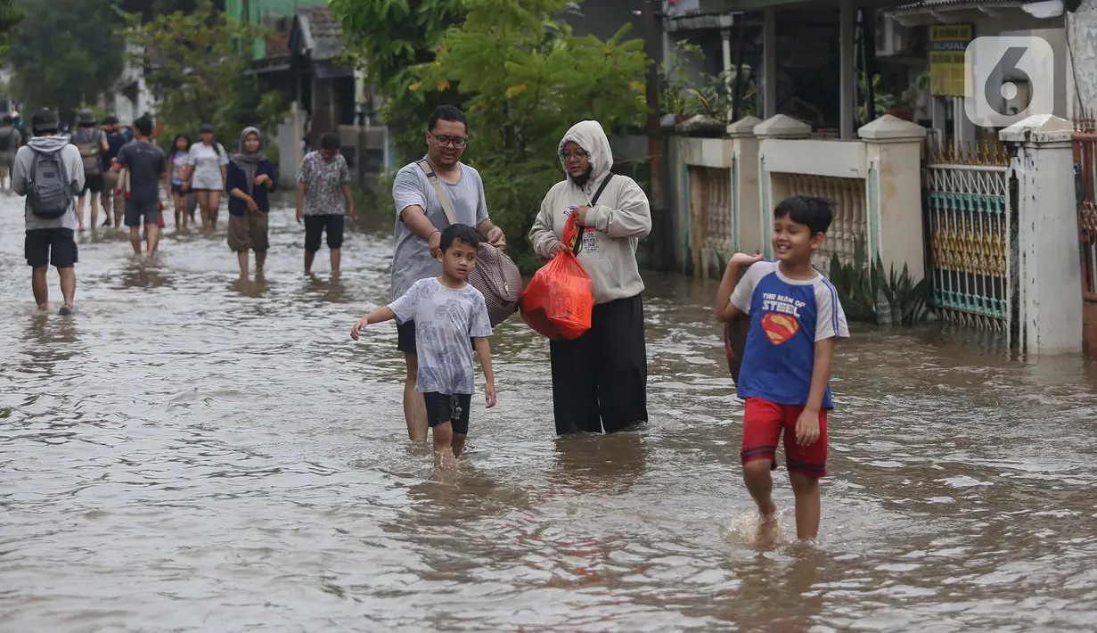 Warga melintasi genangan air di Perumahan Ciledug Indah 1, Kota Tangerang, Banten, Selasa (4/3/2025). (Liputan6.com/Angga Yuniar)
