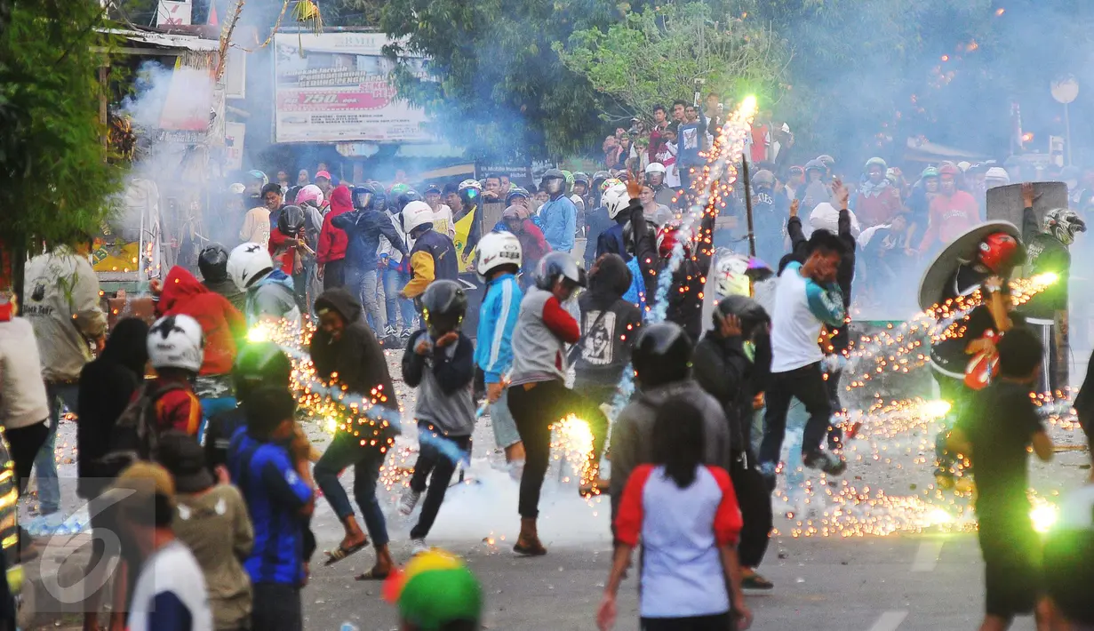 Sejumlah orang mencoba menghindari lemparan petasan dalam tawuran antarwarga di dekat Stasiun Manggarai, Jakarta Selatan, Minggu (8/1). Belum diketahui adanya korban jiwa maupun penyebab tawuran tersebut. (Liputan6.com/Angga Yuniar)