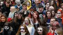 Orang-orang mengenakan kostum dan dandanan menyerupai zombie ketika berpartisipasi dalam 'Zombie Walk' di pusat Kota Kiev, Ukraina, 26 Oktober 2019. Menjelang perayaan Halloween pada 31 Oktober mendatang, warga di beberapa belahan dunia sudah mulai melakukan acara bertema horor. (AP/Efrem Lukatsky)