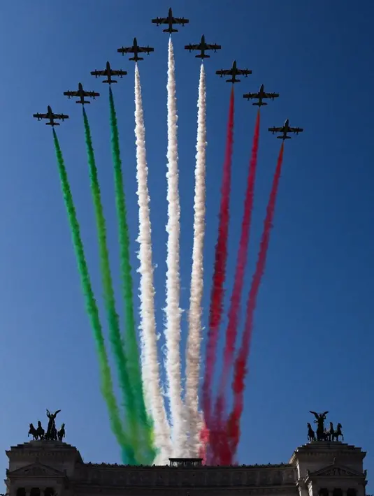 <p>Pesawat Aermacchi MB-339 dari unit aerobatik Angkatan Udara Italia "Frecce Tricolori" (Panah Tiga Warna) menyebarkan asap dengan warna bendera Italia untuk menandai Hari Republik ke-77 di atas Altare della Patria - monumen Raja Vittorio Emanuele II - di Roma, Italia, 2 Juni 2023. (VINCENZO PINTO/AFP)</p>