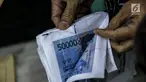 Petugas Direktorat Tindak Pidana Ekonomi Khusus Bareskrim Polri memperlihatkan uang palsu saat rilis di Bareskrim Polri, Jakarta, Jumat (16/6). Bareskrim Mabes Polri menangkap seorang pembuat uang palsu bernama Muhammad Amin. (Liputan6.com/Faizal Fanani)