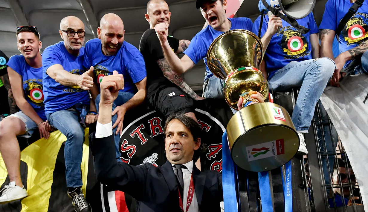 <p>Pelatih Inter Milan Simone Inzaghi memegang trofi saat merayakan dengan para penggemar setelah Inter Milan memenangkan pertandingan final Coppa Italia 2021/2022 4-2 atas Juventus di Stadion Olimpico, Roma, Kamis (12/5/2022) dini hari WIB. Bagi Inter Milan, ini gelar juara Coppa Italia 2021/2022 kedelapan setelah sebelumnya sukses menjadi kampiun turnamen ini pada 1939, 1978, 1982, 2005, 2006, 2010, dan 2011. (Isabella BONOTTO / AFP)</p>
