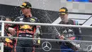 Pebalap Red Bull Max Verstappen disemprot menggunakan sampanye oleh pebalap Daniil Kvyat usai dirinya memenangkan F1 GP Jerman di Hockenheimring, Hockenheim, Minggu (28/7/2019). Ini adalah kemenangan kedua Verstappen pada persaingan F1 GP 2019. (AP Photo/Jens Meyer)