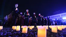 Sejumlah orang ambil bagian dalam acara penyalaan lilin untuk mengenang para korban Pembantaian Nanjing di hari peringatan nasional ketujuh di Balai Peringatan Korban Pembantaian Nanjing oleh Tentara Jepang di Nanjing, ibu kota Provinsi Jiangsu, China timur, pada 13 Desember 2020. (Xinhua/Li Bo)