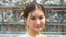 Untuk tampilan kedua, Sarwendah memilih Chut Thai dengan selendang merah bermotif emas, dipadukan dengan kain bawahan bercorak emas. Sarwendah juga mengenakan aksesori emas dari anting, kalung, hingga sabuk. Rambutnya ditata dengan gaya sanggul modern lengkap dengan tusuk konde emas. (Liputan6.com/IG/@sarwendah29)