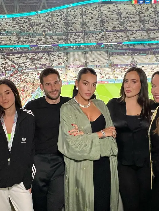 Model 28 tahun itu memakai dress strapless hitam dengan outerwear warna khakhi. [@georginagio]