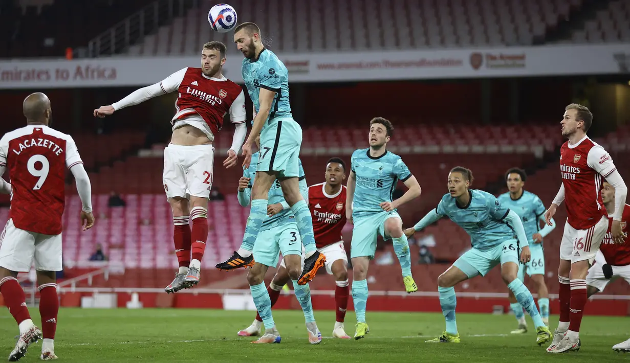 Pemain Liverpool Nathaniel Phillips (kanan) duel udara saat memperebutkan bola dengan pemain Arsenal Calum Chambers pada pertandingan Liga Inggris di Emirates Stadium, London, Inggris, Sabtu (3/4/2021). Liverpool membantai Arsenal dengan skor 3-0. (Julian Finney/Pool via AP)