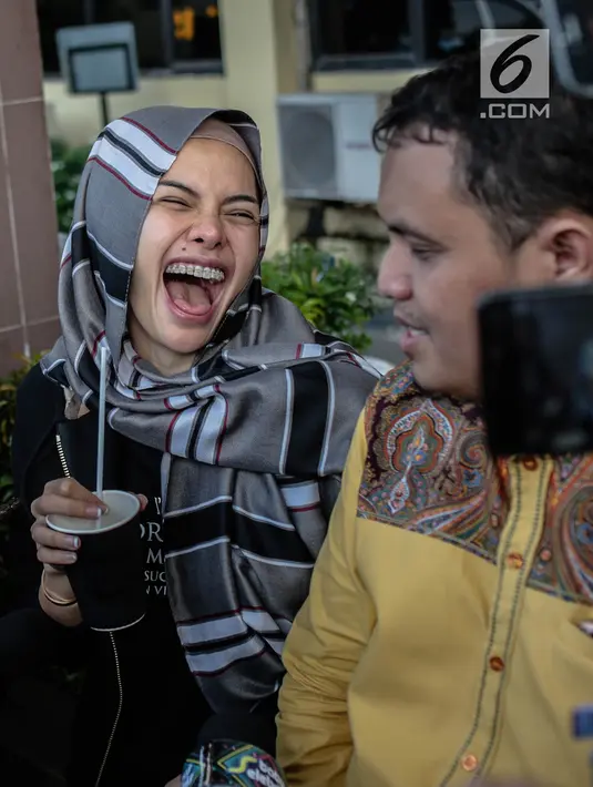 Aktris Nikita Mirzani tertawa saat mendatangi Polres Metro Jakarta Selatan, Rabu (24/10). Kedatangan Niki menjalani pemeriksaan terkait laporannya terhadap pengusaha Sam Aliano. (Liputan6.com/Faizal Fanani)