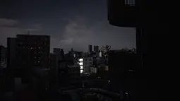 Pemandangan umum menunjukkan bangunan tempat tinggal selama pemadaman listrik setelah gempa berkekuatan 7,3 SR mengguncang Jepang timur di distrik Koto di Tokyo, Kamis (17/3/2022). Gempa kuat Magnitudo 7,3 membuat lebih dari 2 juta rumah di daerah Tokyo menjadi gelap gulita. (AFP/Philip Fong)
