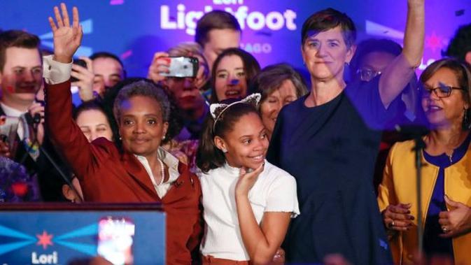 Lori Lightfoot (baju merah tua sebelah kiri) merayakan kemenangannya pada hari Rabu bersama istri dan putrinya. (AFP)