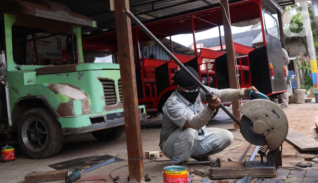 Pekerja menyelesaikan pembuatan mobil wisata Odong-Odong di bengkel perakitan milik Didik Hermawan di Jurangmangu, Tangerang Selatan, Sabtu (27/2/2021). Pada masa pandemi Covid-19, permintaan mobil odong-odong tetap stabil melalui transaksi pasar online. (Liputan6.com/Angga Yuniar)