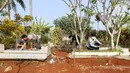 Pelanggar PSBB dihukum membersihkan makam di kawasan Stadion Pakansari, Kabupaten Bogor, Minggu (6/9/2020). Pemkab Bogor menghukum pelanggar PSBB dengan denda Rp 100 ribu serta sanksi sosial seperti membersihkan area makam, push up, dan mempraktikkan prosesi pemakaman. (Liputan6.com/Herman Zakharia)