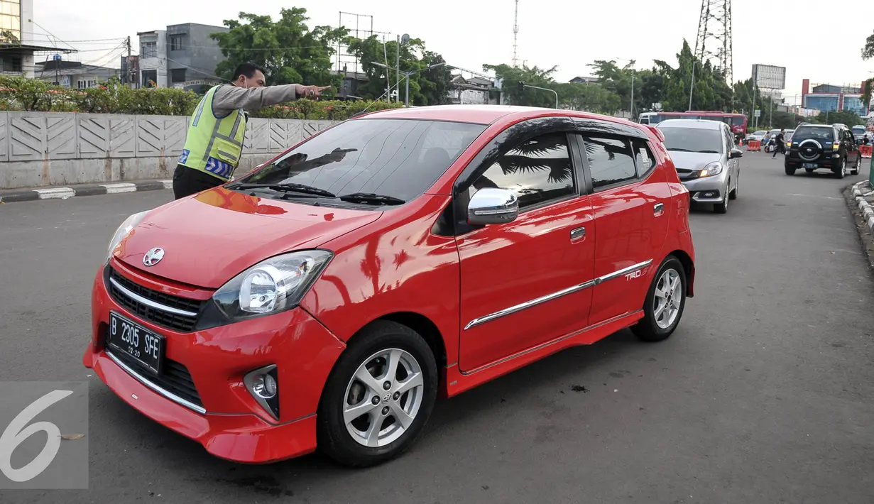 Petugas mengarahkan pengedara yang akan melintas di jalur uji coba penutupan perlintasan kereta Senen, Jakarta, Sabtu (1/10). Dalam uji coba ini Kemenhub bekerjasama dengan Pemprov DKI Jakarta dan Polda Metro Jaya. (Liputan6.com/Yoppy Renato)