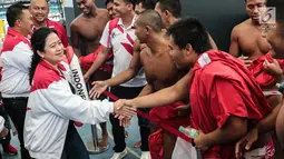 Menko PMK Puan Maharani memberikan ucapan selamat kepada timnas polo air putra Indonesia usai melawan Filipina di National Aquatic Centre, Kuala Lumpur, Minggu (20/8). Timnas polo air putra Indonesia menyabet medali perak. (Liputan6.com/Faizal Fanani)