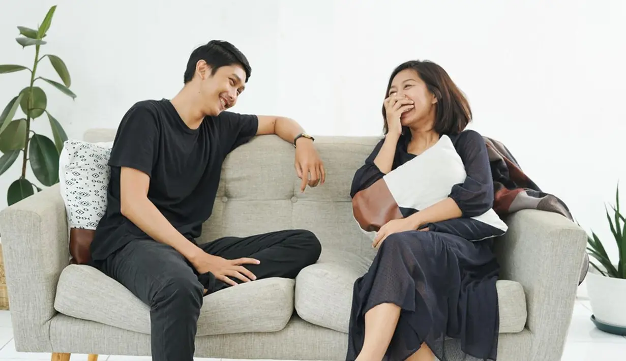 Merekam momen tertawa dan mengobrol berdua di sofa seperti ini juga romantis, lho. Romantis tak harus dengan gestur sentuhan atau pelukan. Bisa tertawa bersama seperti ini juga sudah manis./Copyright shutterstock.com/g/KamaraStudio